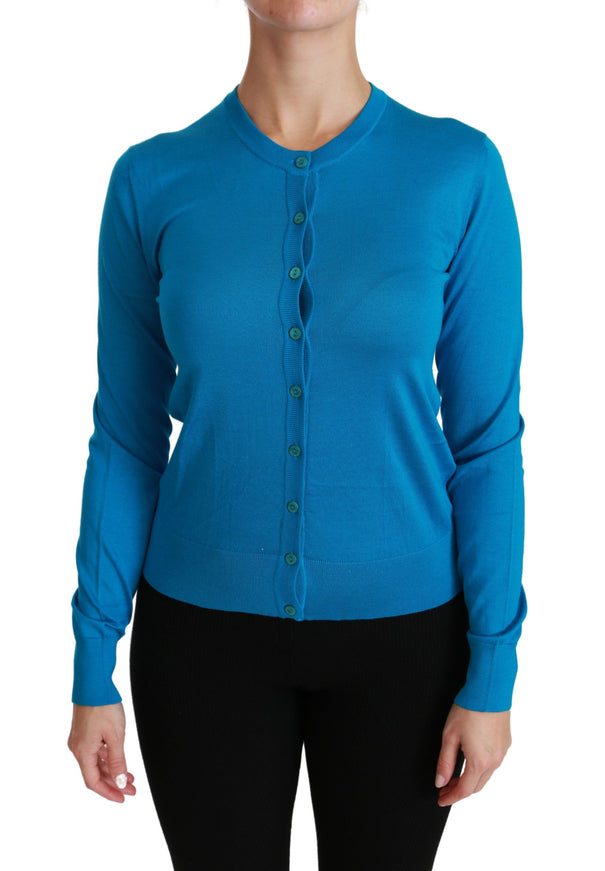 a woman wearing a blue cardigan and black pants