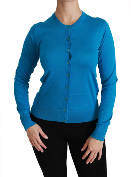 a woman wearing a blue cardigan and black pants