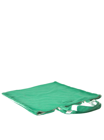 a green blanket laying on top of a white wall