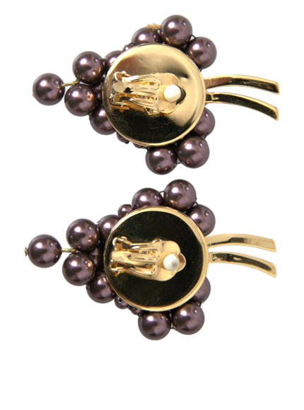 a pair of black and gold brooches with pearls