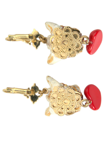 a pair of red and gold earrings on a white background