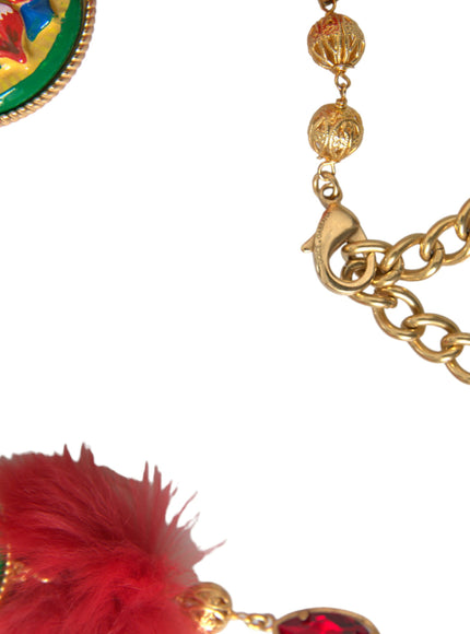 a close up of a chain with a red feather on it