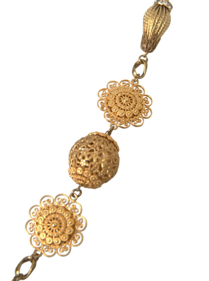 a gold necklace with three balls on it