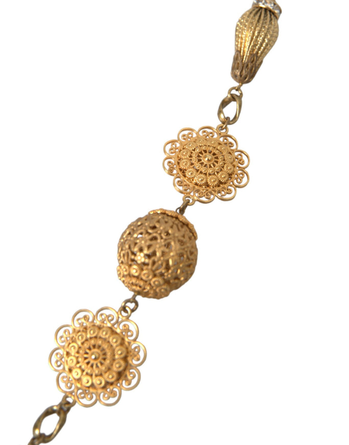 a gold necklace with three balls on it