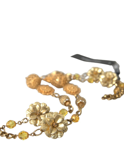 a gold necklace with flowers and beads on a white background