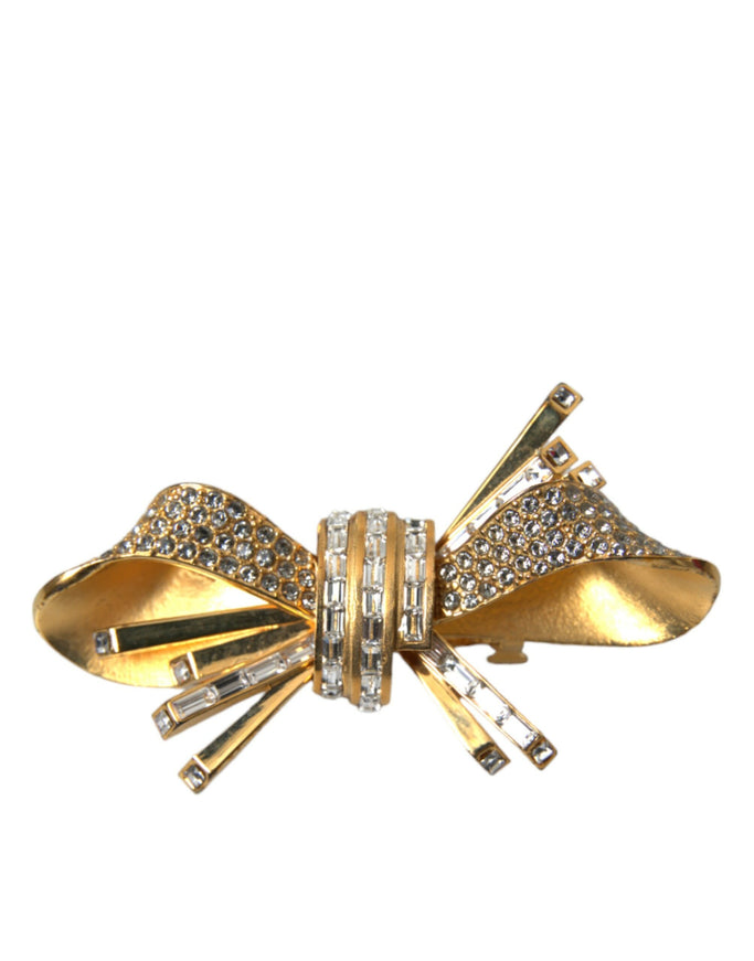 a gold bow brooch with crystal stones