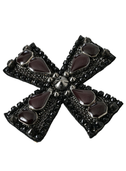 a black brooch with hearts on it