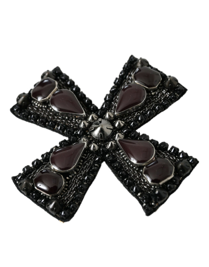 a black brooch with hearts on it