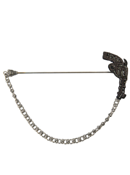 a black and white brooch with a chain attached to it