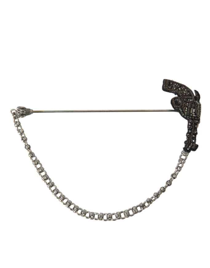 a black and white brooch with a chain attached to it