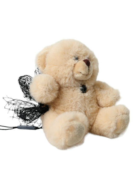 a stuffed teddy bear with a black ribbon around its neck