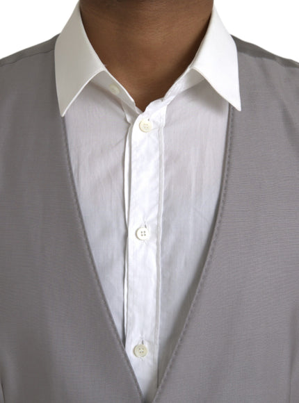 a close up of a person wearing a white shirt and gray vest