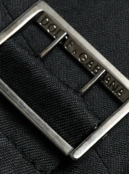 a close up of a metal buckle on a black suit