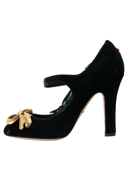 a black high heeled shoe with a gold bow