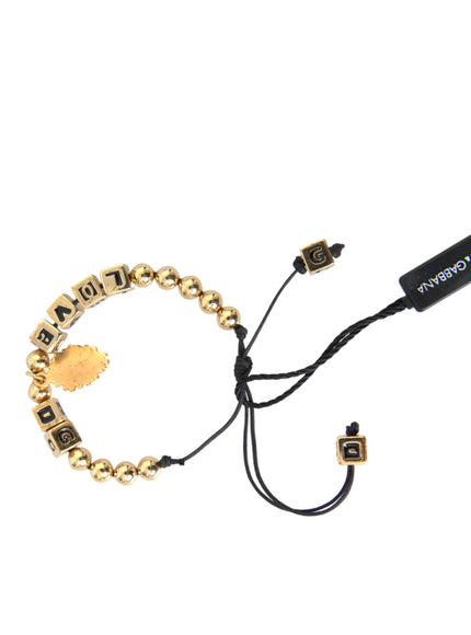 a gold beaded bracelet with a black cord