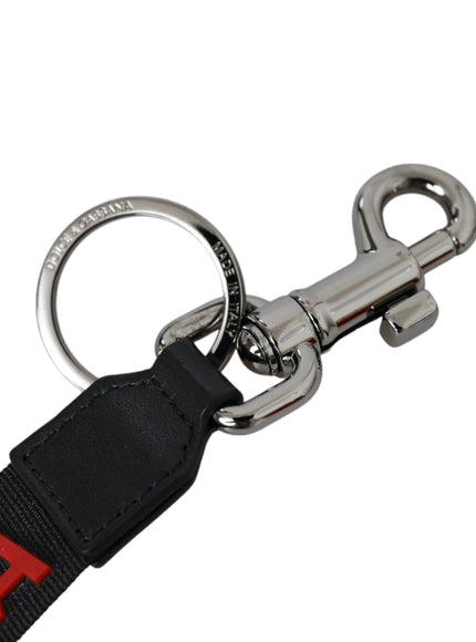 a black key chain with a red letter on it