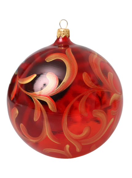 a red glass ornament with a picture of a bird on it