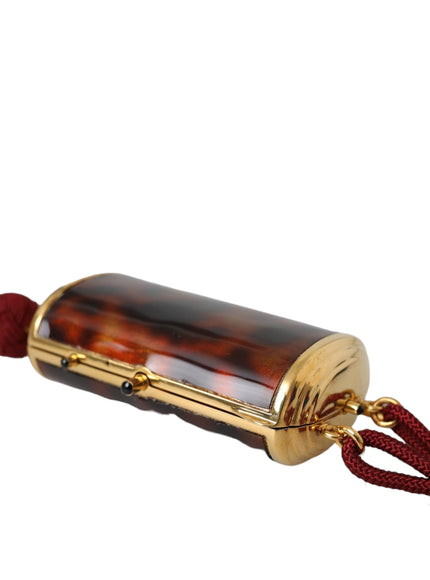 a gold and tortoise shell pendant on a red cord