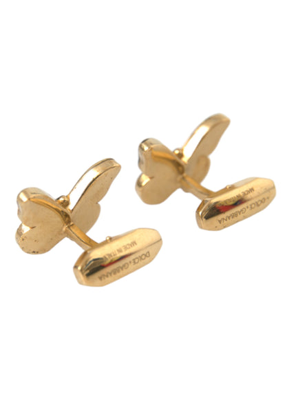 a pair of gold toned cufflinks with a curved design