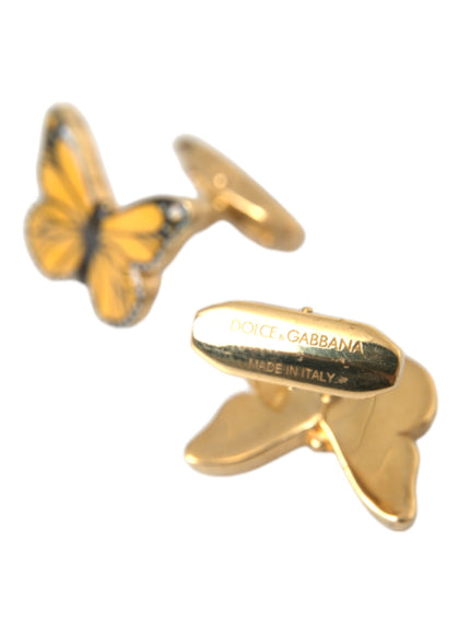 a pair of gold cufflinks with a butterfly on it