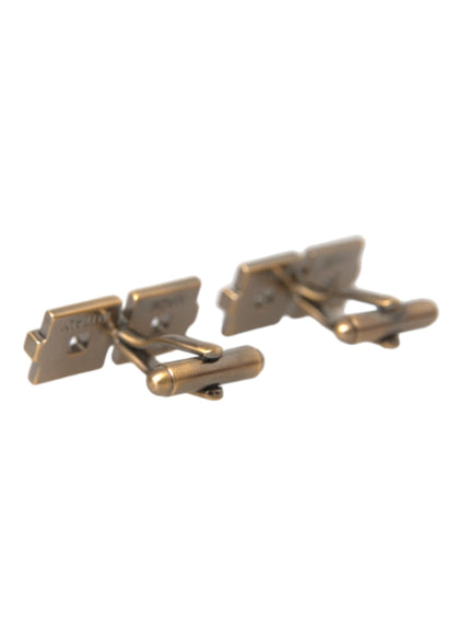 a pair of gold cufflinks on a white background