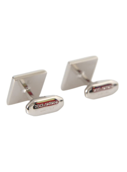 a pair of silver cufflinks with a white background