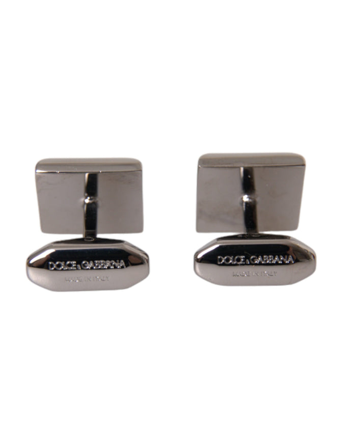 a pair of silver cufflinks on a white background