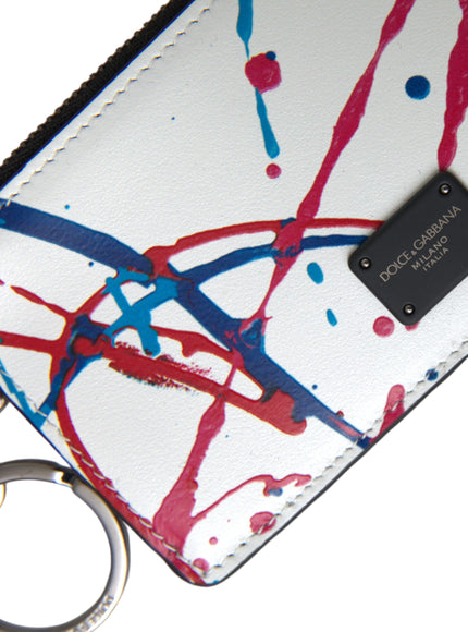 a white purse with a red, blue, and black paint splattered design