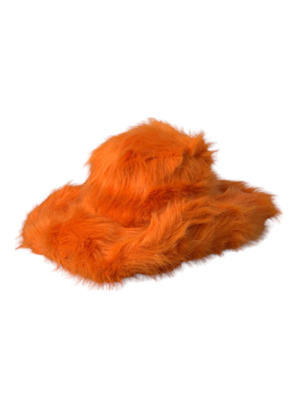 an orange furry animal laying on top of a white surface