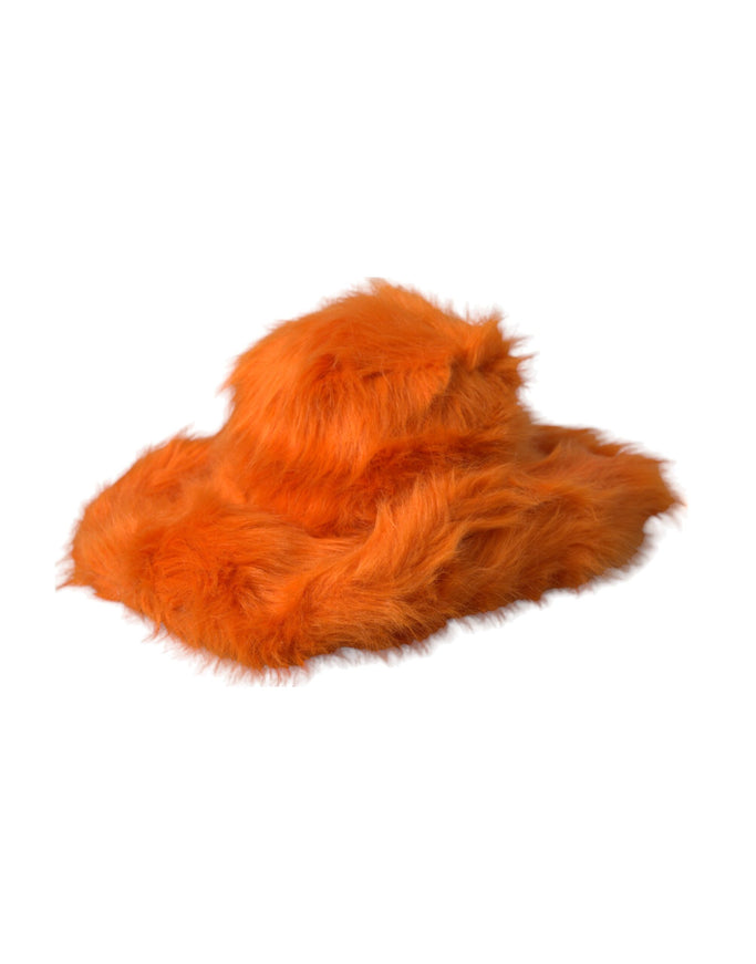 an orange furry animal laying on top of a white surface