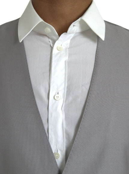 a close up of a person wearing a white shirt and gray vest