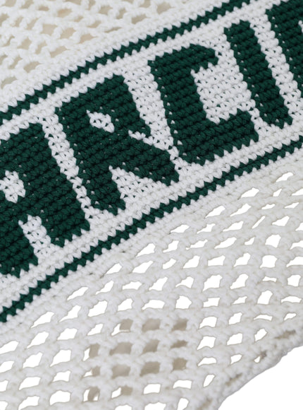 a close up of a white and green knitted blanket