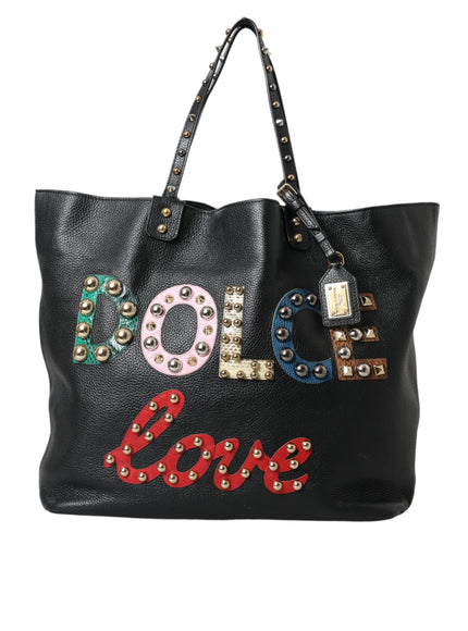 a black leather bag with studded letters on it