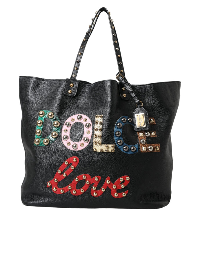 a black leather bag with studded letters on it