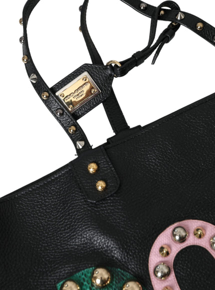 a black handbag with a pink and green decoration