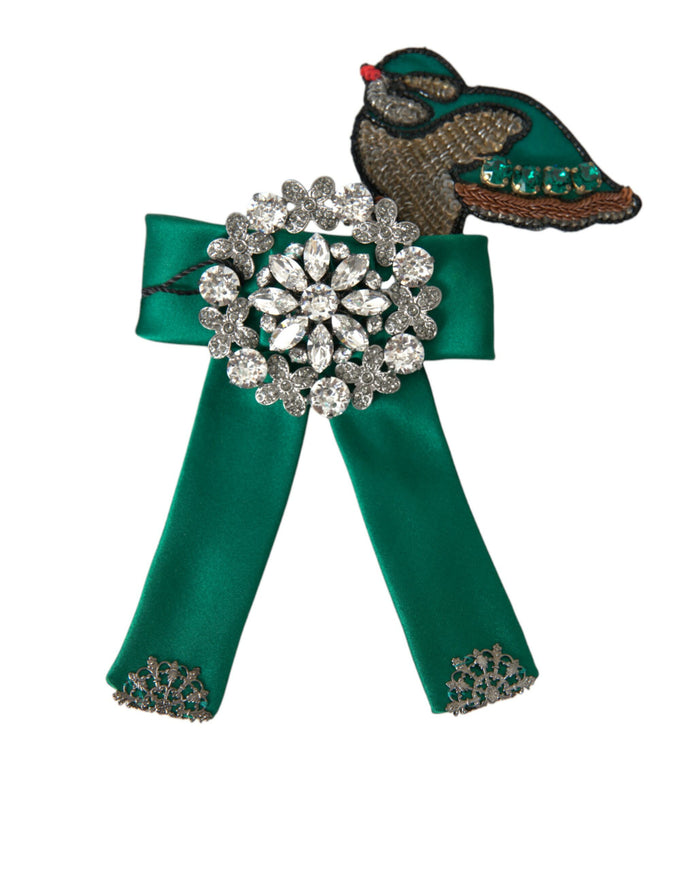 a green ribbon with a brooch on top of it