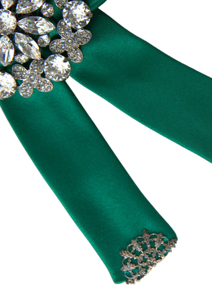 a close up of a green ribbon with a brooch on it