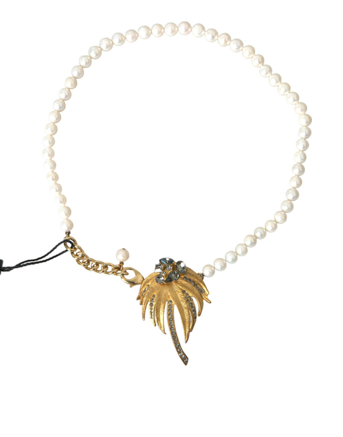 a pearl necklace with a gold leaf charm