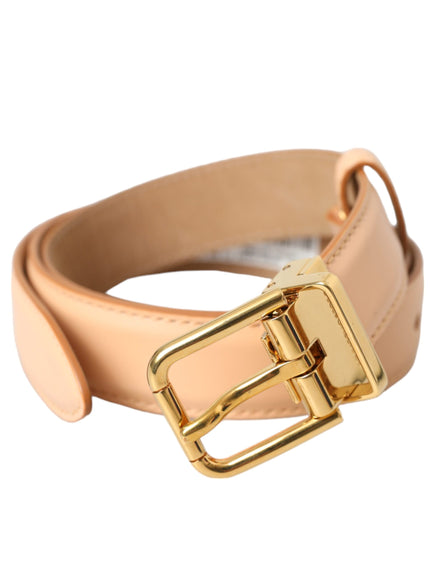 a gold buckle on a tan leather belt