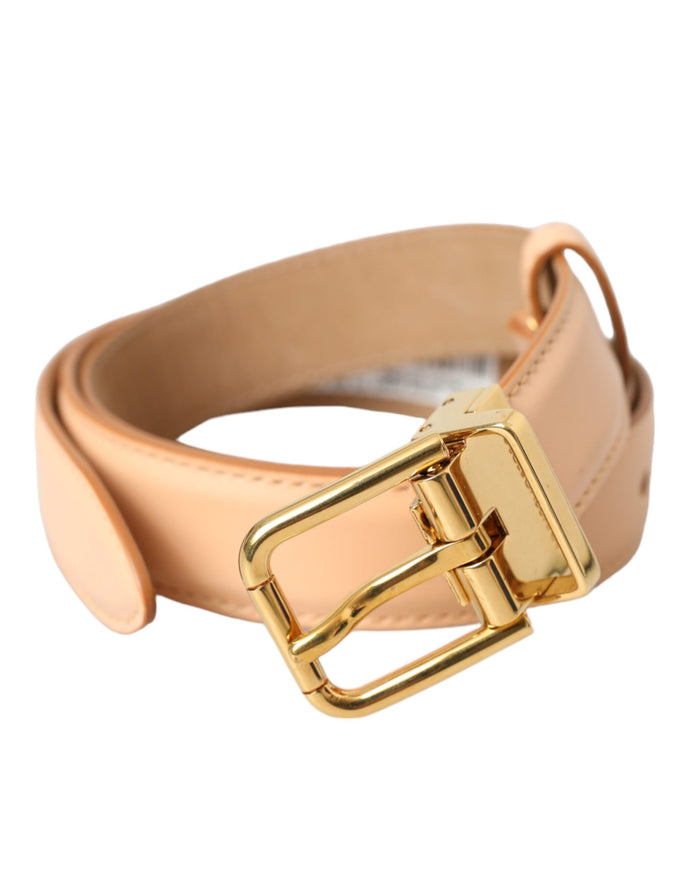 a gold buckle on a tan leather belt