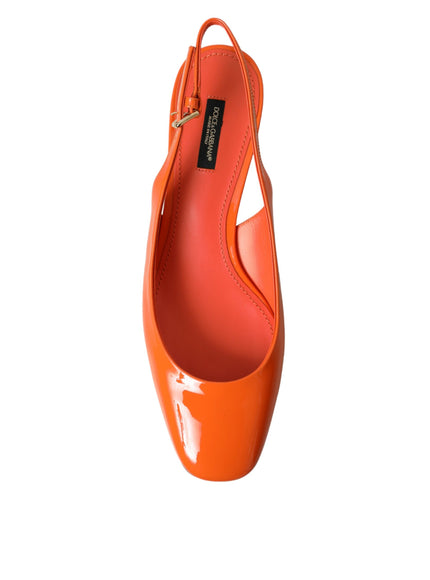 a woman's orange high heel shoe on a white background