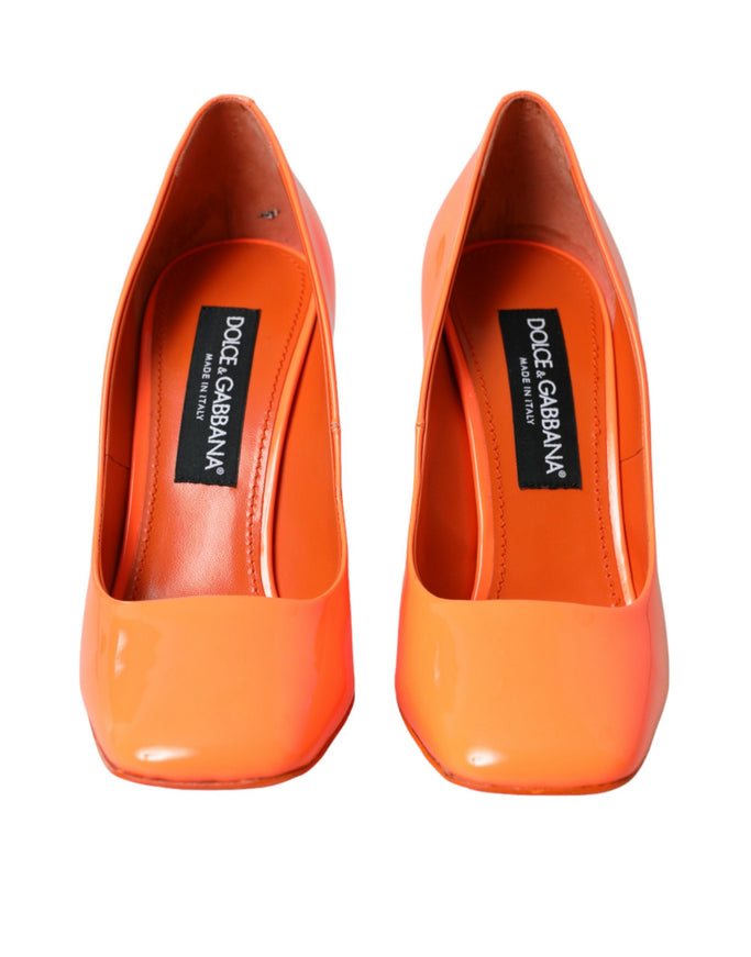 a pair of orange high heels on a white background