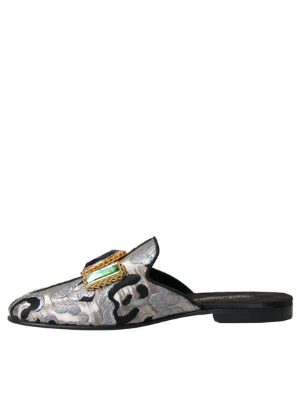 a white and black slipper with a green and gold buckle