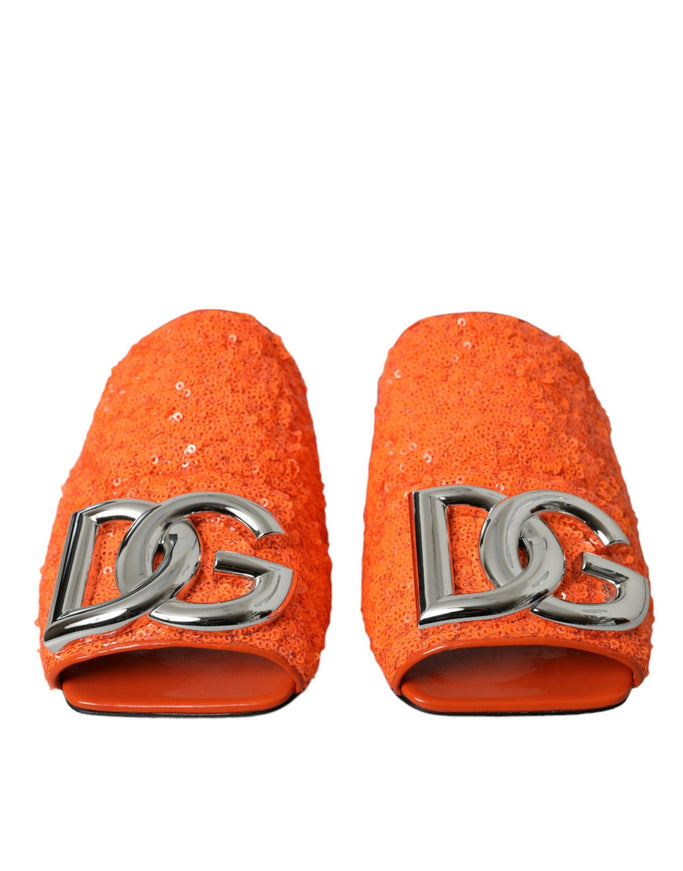 a pair of orange slippers with a silver logo