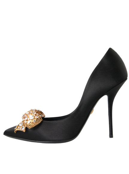 a black high heel shoe with a gold bow