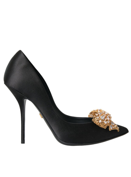 a black high heel shoe with a gold bow