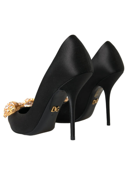 a pair of black high heels with a gold chain