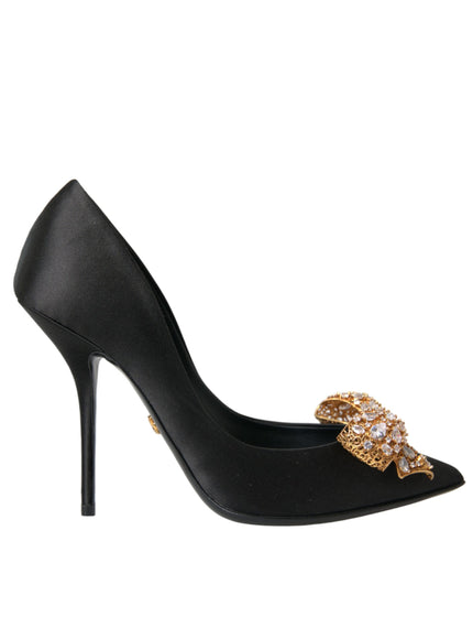 a black high heel shoe with a gold bow