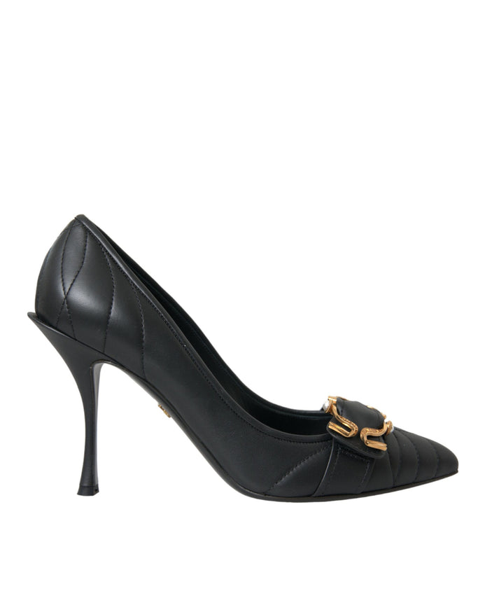 a black high heeled shoe with a gold buckle