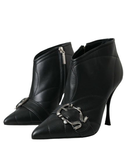 a pair of black high heeled boots with a metal buckle